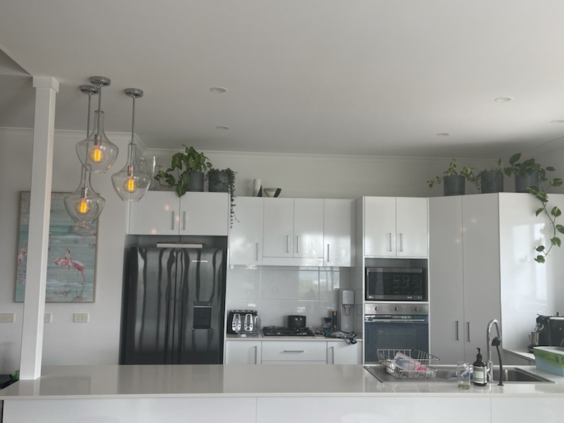 Kitchen with three pendant lights lit above the island bench